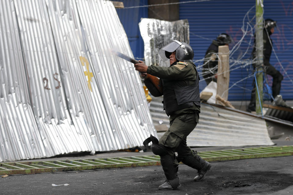 Police fire tear gas at backers of former President Evo Morales marching in La Paz, Bolivia, Wednesday, Nov. 13, 2019. Bolivia's new interim president Jeanine Anez faces the challenge of stabilizing the nation and organizing national elections within three months at a time of political disputes that pushed Morales to fly off to self-exile in Mexico after 14 years in power. (AP Photo/Natacha Pisarenko)