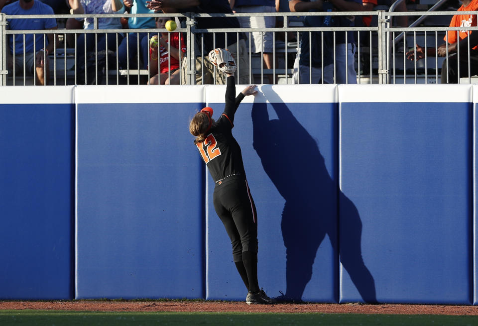 Oregon State outfielder Eliana Gottlieb (12) reaches for a Florida home run during the fifth inning of an NCAA softball Women's College World Series game Thursday, June 2, 2022, in Oklahoma City. (AP Photo/Alonzo Adams)