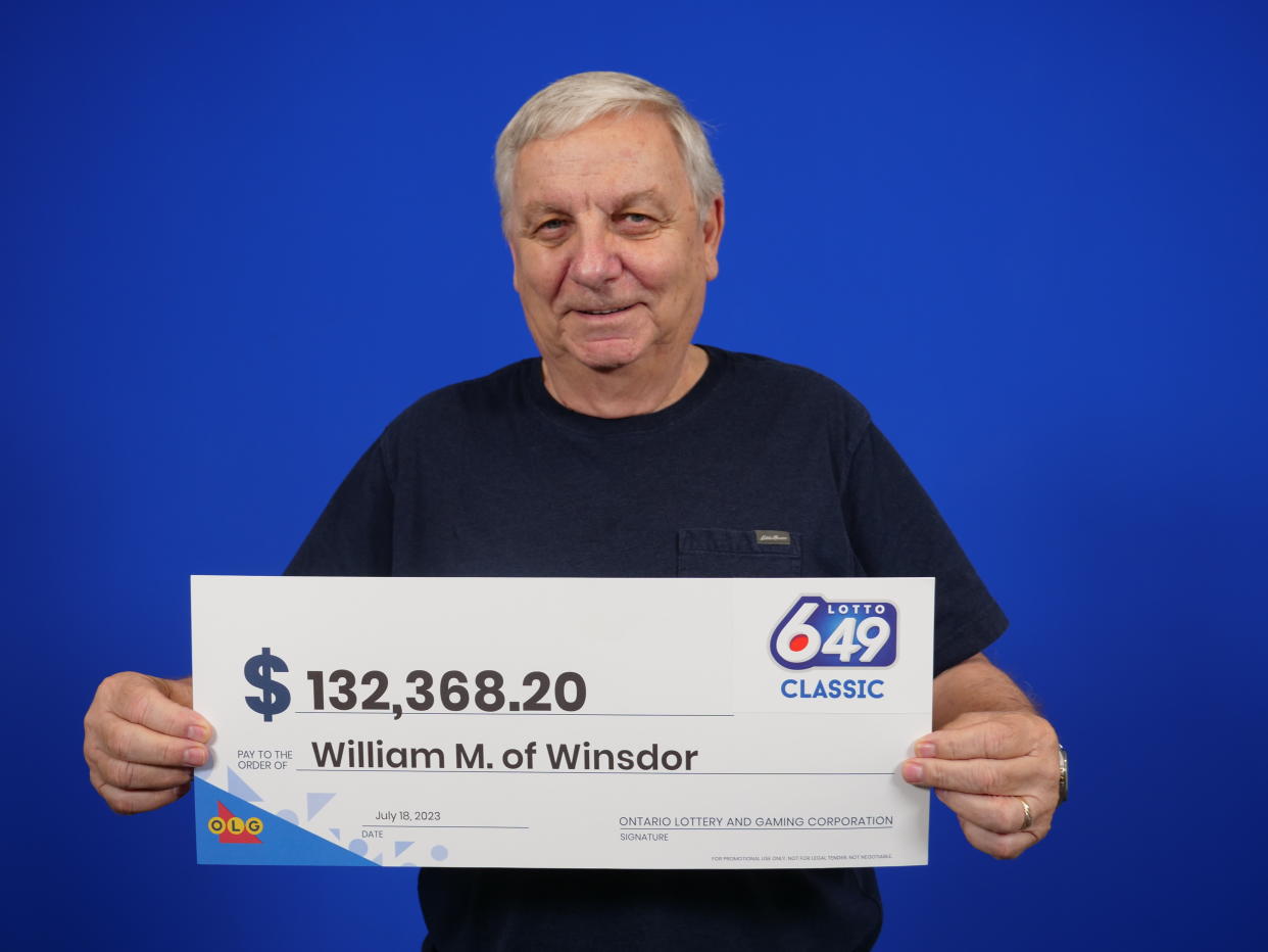 Man holding a $132K lotto cheque from OLG.