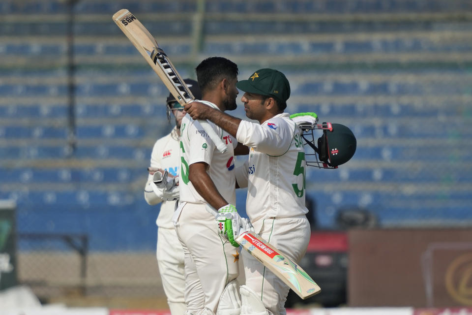 Pakistan's Babar Azam, left, is congratulated by teammate Sarfraz Ahmed after scoring century during the first day of first test cricket match between Pakistan and New Zealand, in Karachi, Pakistan, Monday, Dec. 26, 2022. (AP Photo/Fareed Khan)