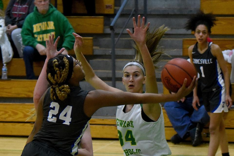 Zanesville sophomore Kandrea Sowers scoops up a shot against defense from Newark Catholic senior Chloe Peloquin. The Green Wave defeated the visiting Lady Devils 40-36 on Wednesday, Jan. 26, 2022.