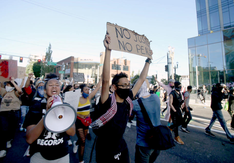 Marchers move west on Burnside towards the Burnside Bridge in Portland, Tuesday evening, June 2, 2020. Protests continued for a sixth night in Portland, demonstrating against the death of George Floyd, a black man who died in police custody on Memorial Day in Minneapolis. (Sean Meagher/The Oregonian via AP)