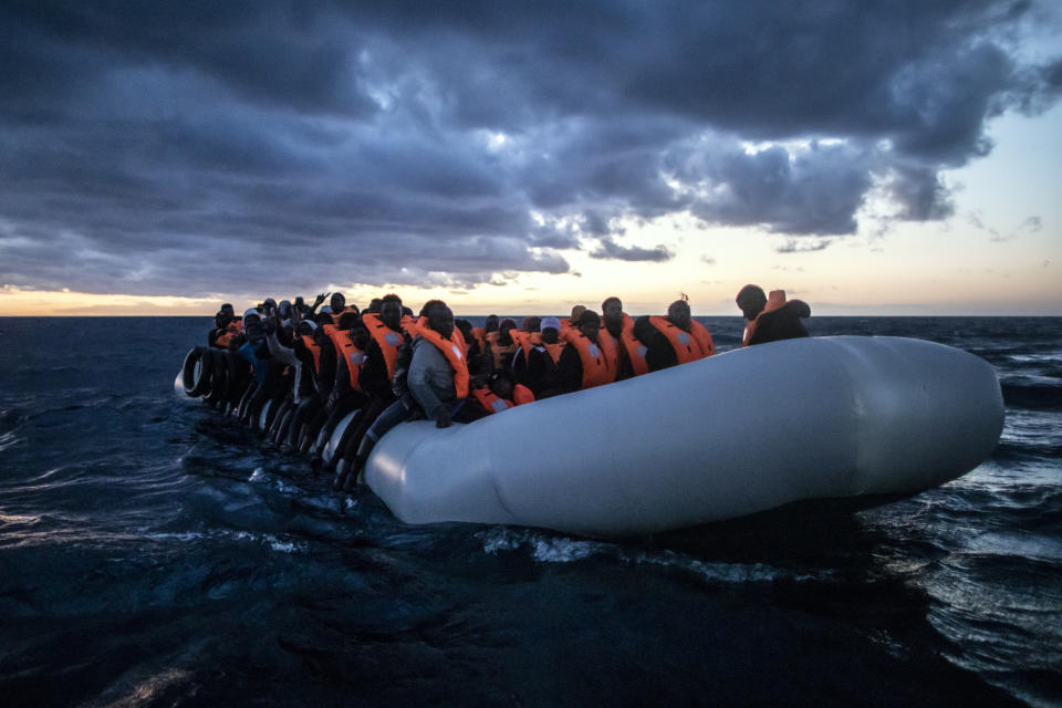 Migrantes y refugiados de distintos países de África viajan a bordo de una atestada embarcación neumática mientras rescatistas de la ONG española Open Arms se acercan con su barco, en aguas internacionales del Mar Mediterráneo, a 80 millas de la costa de Libia, el 13 de febrero de 2021. En los últimos días, las autoridades libias han impedido ocho intentos de rescate por parte del Open Arms, el barco de la ONG española del mismo nombre, acosando y amenazando a su tripulación. (AP Foto/Bruno Thevenin)