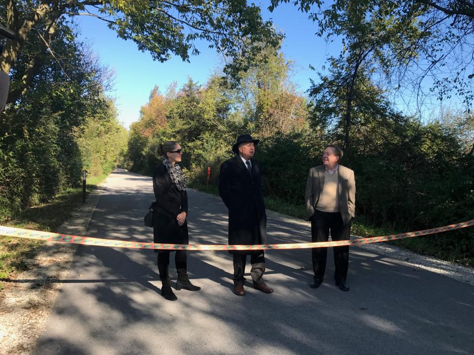 Anna Gremling with the Indianapolis Metropolitan Planning Organization (from left), Westfield Mayor, Andy Cook and Carmel Mayor, Jim Brainard prepare to cut the ribbon and open the last section of the Monon Trail in Westfield on Oct. 16, 2018.