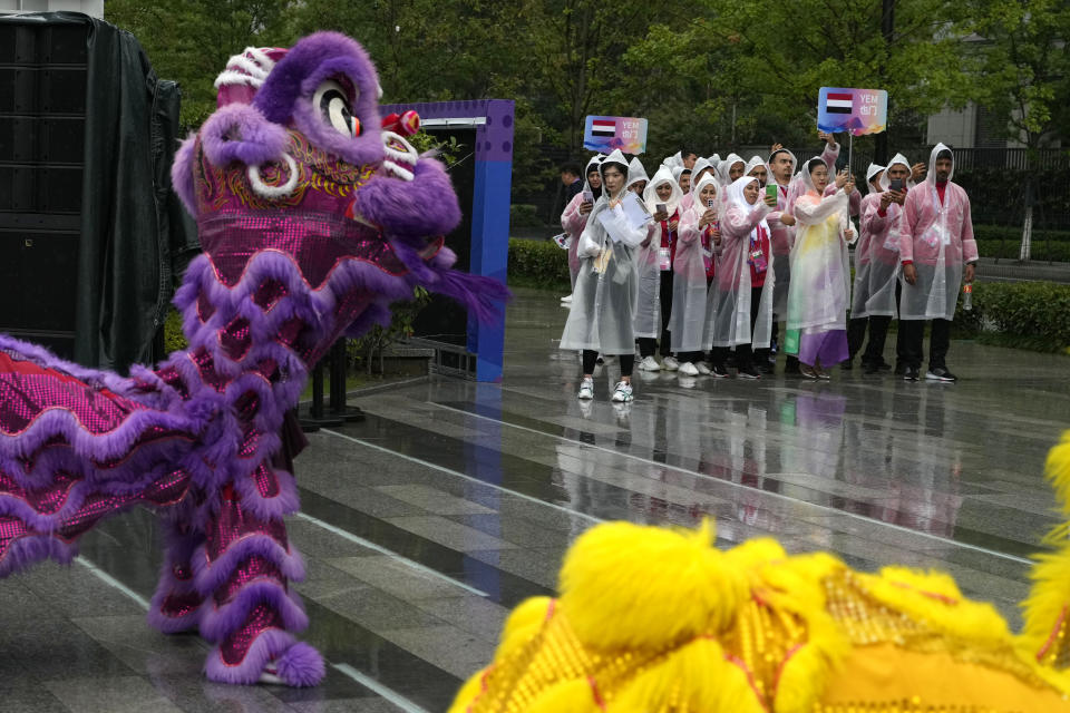 Athletes from Yemen take photos of a dragon dance performance during the team welcoming ceremony at the 19th Asian Games in Hangzhou, China, Thursday, Sept. 21, 2023. The Asian Games are an attention grabber. For starters, they involve more participants than the Summer Olympics. Organizers say more than 12,000 will be entered as the opening ceremony takes place Saturday, Sept. 23 in the eastern Chinese city of Hangzhou. (AP Photo/Ng Han Guan)