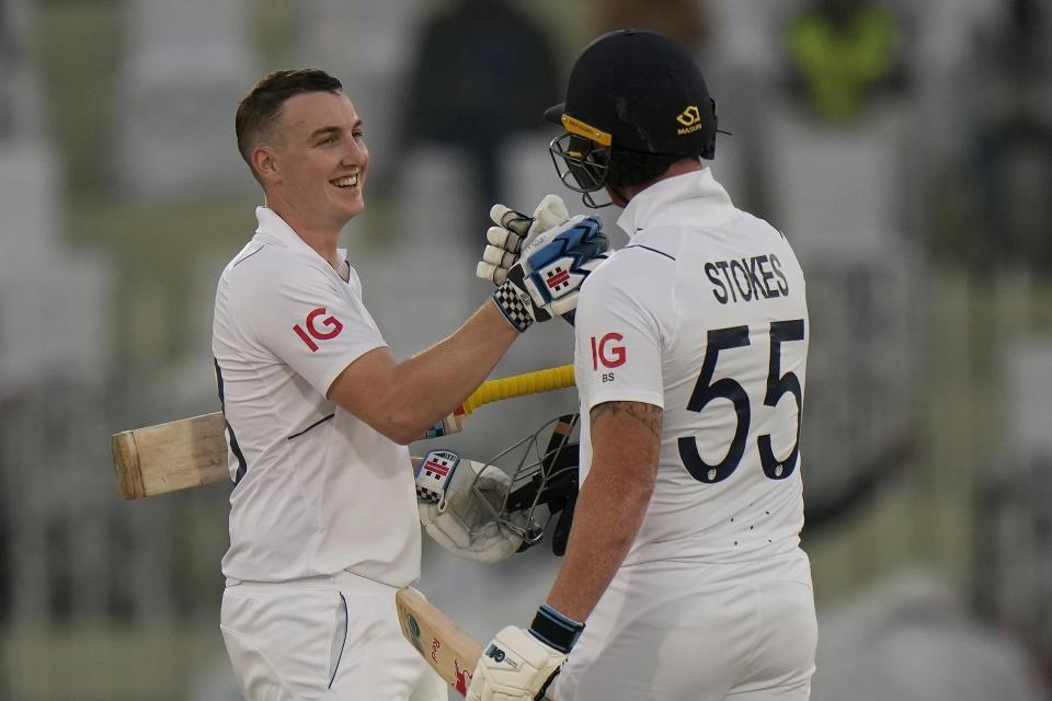 England's Harry Brook, left, is congratulated by teammate Ben Stokes after scoring century during the first day of the first test cricket match between Pakistan and England, in Rawalpindi, Pakistan, Dec. 1, 2022. (AP Photo/Anjum Naveed)