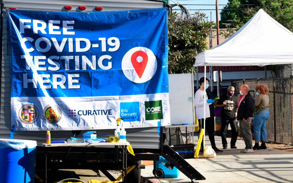 People check-in at a pop-up Covid-19 Test site in Los Angeles, California - AFP