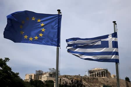 A European Union flag (L) and a Greek national flag flutter as the ancient Parthenon temple is seen in the background in Athens June 1, 2015. REUTERS/Alkis Konstantinidis