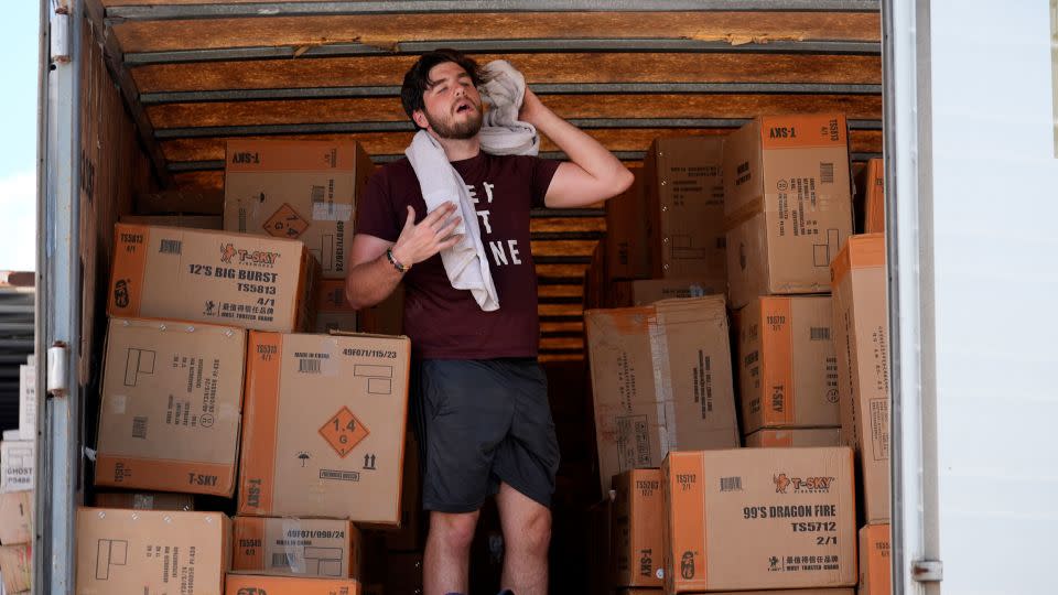 Ethan Hickman takes a break while unloading a trailer of fireworks in Weldon Spring, Missouri, on June 17, 2024. - Jeff Roberson/AP