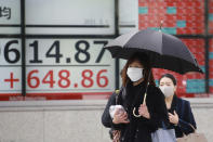 People walk by an electronic stock board of a securities firm in Tokyo, Monday, March 1, 2021. Asian shares were higher on Monday on hopes for President Joe Biden’s stimulus package and bargain-hunting buying after the shares’ fall last week. (AP Photo/Koji Sasahara)