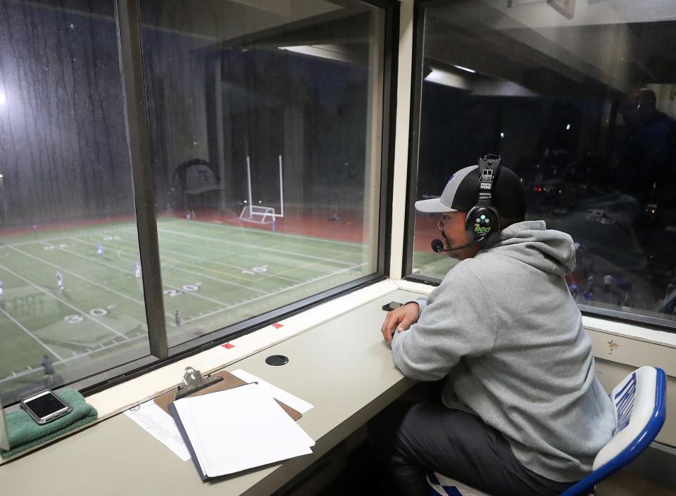 Olympic Trojans offensive coordinator Erwin Quitevis calls plays from the press box of the stadium during their game against the Port Angeles Roughriders on Thursday, Sept. 29, 2022.