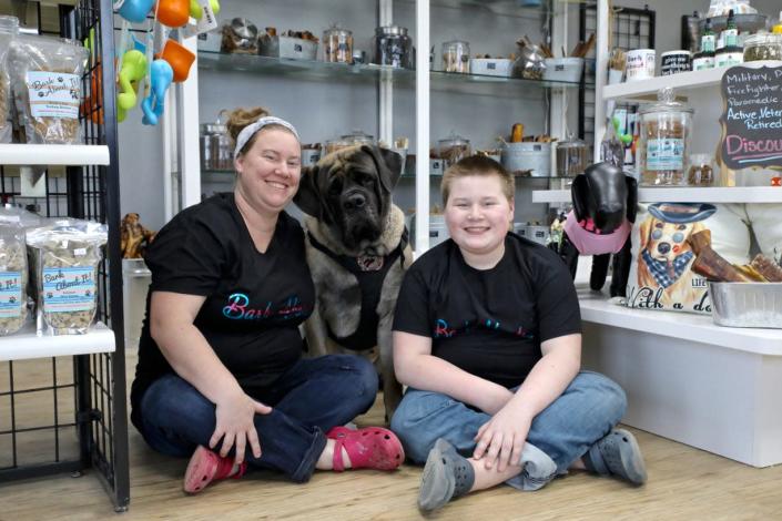 Lauren Randall, left, and her son Charlie Randall, 12, sit with four-year-old English Mastiff Liberty Bell on Thursday, March 24, 2022, in the Randall&#39;s new family store, Bark About It Animal Boutique in Poplar Grove.