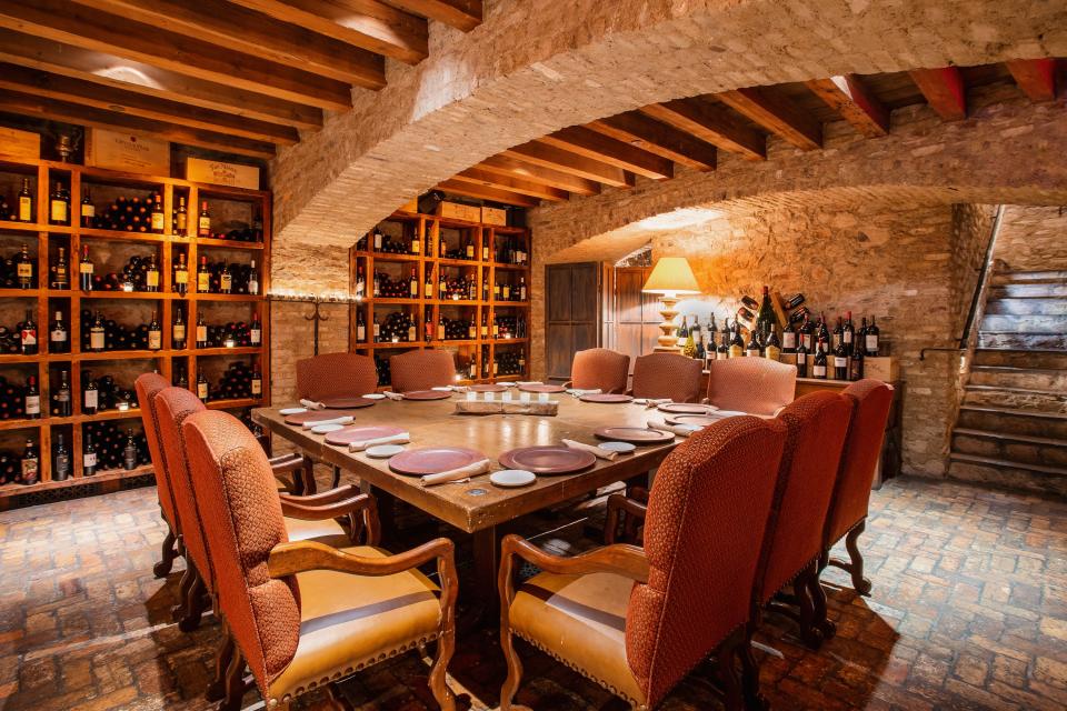 Inside a wine cellar with a square table seating 11 in the middle