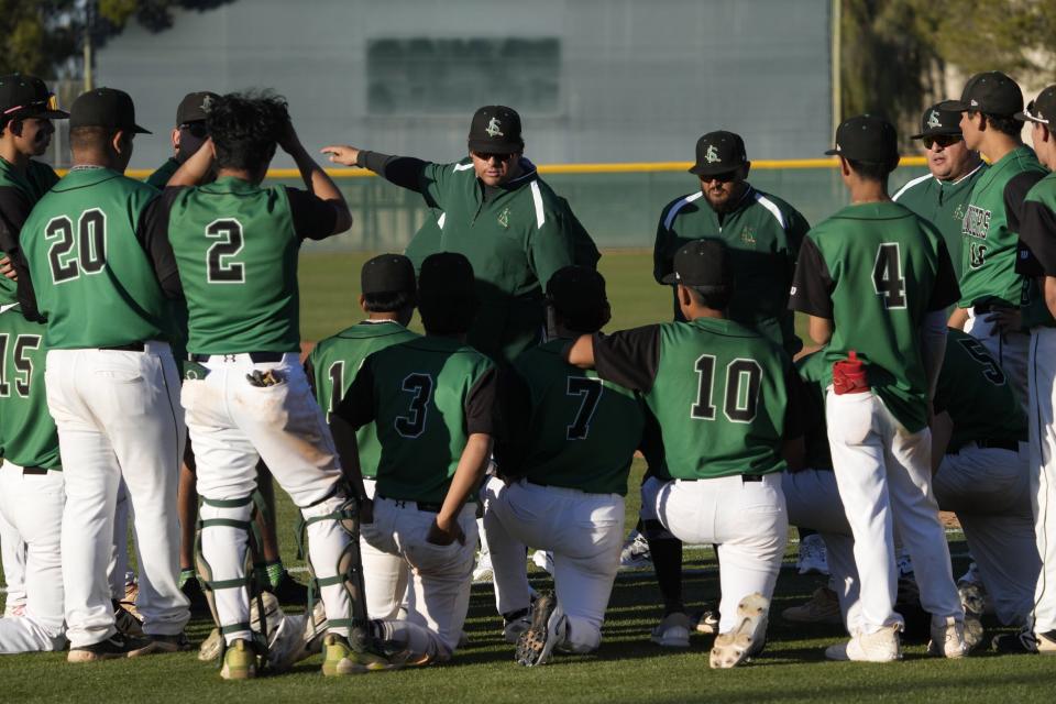 San Luis head coach Cesar Castillo talks to his players after losing 16-6 against Hamilton at Hamilton High school baseball field in Chandler on March 28, 2023.