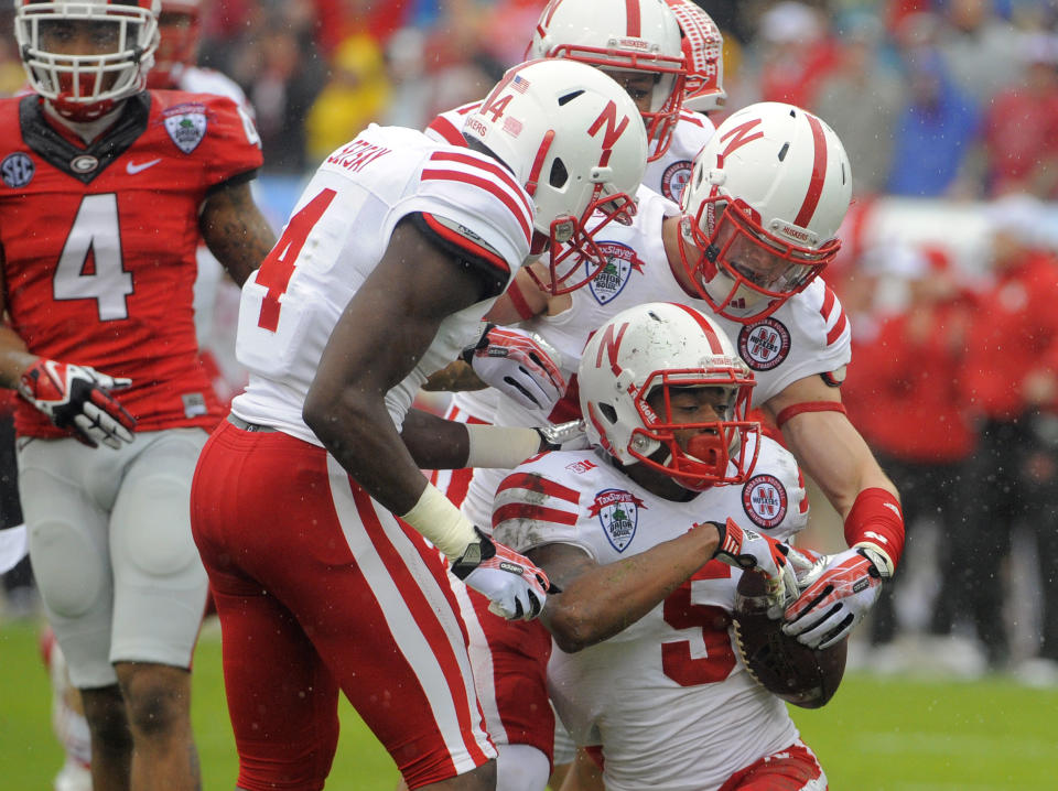 Nebraska cornerback Josh Mitchell (5) celebrates with his teammates after recovering a fumbled kick return during the first half of the Gator Bowl NCAA college football game against Georgia, Wednesday, Jan. 1, 2014, in Jacksonville, Fla. (AP Photo/Stephen B. Morton)