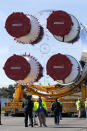 Security personnel walk with the core stage of NASA's Space Launch System rocket, that will be used for the Artemis 1 Mission, as it is moved to the Pegasus barge, at the NASA Michoud Assembly Facility where it was built, in New Orleans, Wednesday, Jan. 8, 2020. It will be transported to NASA's Stennis Space Center in Mississippi for its green run test. (AP Photo/Gerald Herbert)