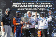 Scott Dixon, second from left, and Chip Ganassi, right, celebrate after winning the NTT IndyCar Series Championship following an IndyCar auto race Sunday, Oct. 25, 2020, in St. Petersburg, Fla. (AP Photo/Mike Carlson)