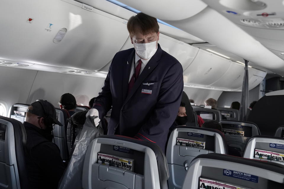 A flight attendant gathers trash on a media flight aboard a Boeing 737 Max airplane from Dallas Fort Worth Airport to Tulsa, Oklahoma in Dallas, Texas, U.S., December 2, 2020. REUTERS/Carlo Allegri