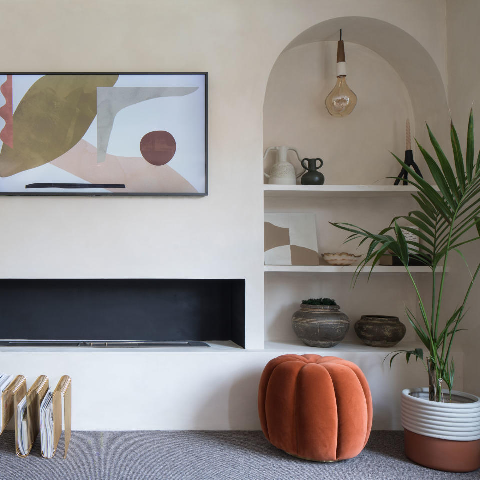 living room with an arched alcove and pendant lights installed within over display shelving