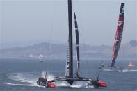 Oracle Team USA (L) sails towards the finish line ahead of Emirates Team New Zealand (R) to win Race 12 of the 34th America's Cup yacht sailing race in San Francisco, California September 19, 2013. REUTERS/Stephen Lam