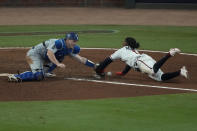 Los Angeles Dodgers catcher Will Smith can not make the tag on Atlanta Braves Ozzie Albies scores on a single by Austin Riley in the eighth inning in Game 2 of baseball's National League Championship Series Sunday, Oct. 17, 2021, in Atlanta. (AP Photo/John Bazemore)