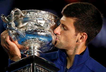 Serbia's Novak Djokovic kisses the men's singles trophy after winning his final match against Britain's Andy Murray at the Australian Open tennis tournament at Melbourne Park, Australia, January 31, 2016. REUTERS/Thomas Peter