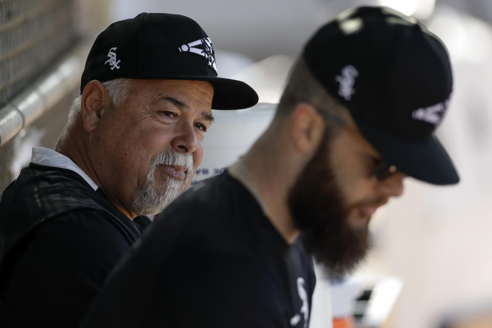 Chicago White Sox manager Rick Renteria, left, talks with pitcher Dallas Keuchel, right, during spring training baseball Saturday, Feb. 15, 2020, in Phoenix. (AP Photo/Gregory Bull)