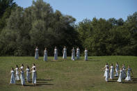 Actresses perform during the lighting of the Olympic flame at Ancient Olympia site, birthplace of the ancient Olympics in southwestern Greece, Monday, Oct. 18, 2021. The flame will be transported by torch relay to Beijing, China, which will host the Feb. 4-20, 2022 Winter Olympics. (AP Photo/Petros Giannakouris)