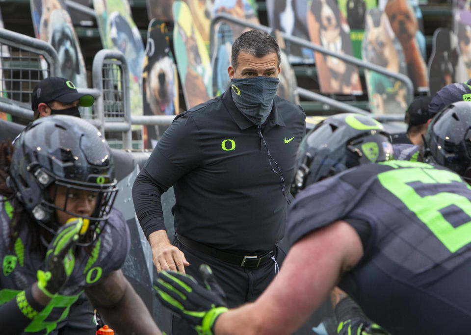 Oregon head coach Mario Cristobal watches his offensive linemen warm up before an NCAA college football game against UCLA, Saturday, Nov. 21, 2020, in Eugene, Ore. (AP Photo/Chris Pietsch)