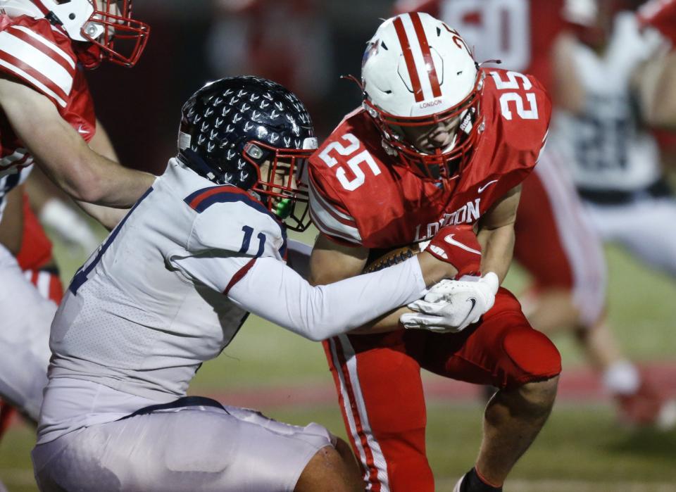 Hartley's Anthony Murphy (11) stops London's Ayden Cooper (25) during their Division III, Region 11 quarterfinal Nov. 5.