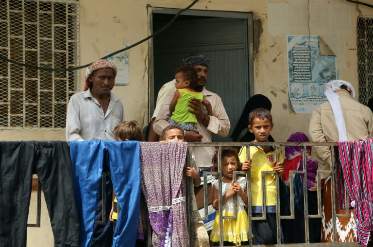 Members of displaced Yemeni families who fled battles between government forces and Huthi fighters near the Hodeida airport stand on the balcony of a school used as temporary housing inside the city of Hodeida on June 17, 2018