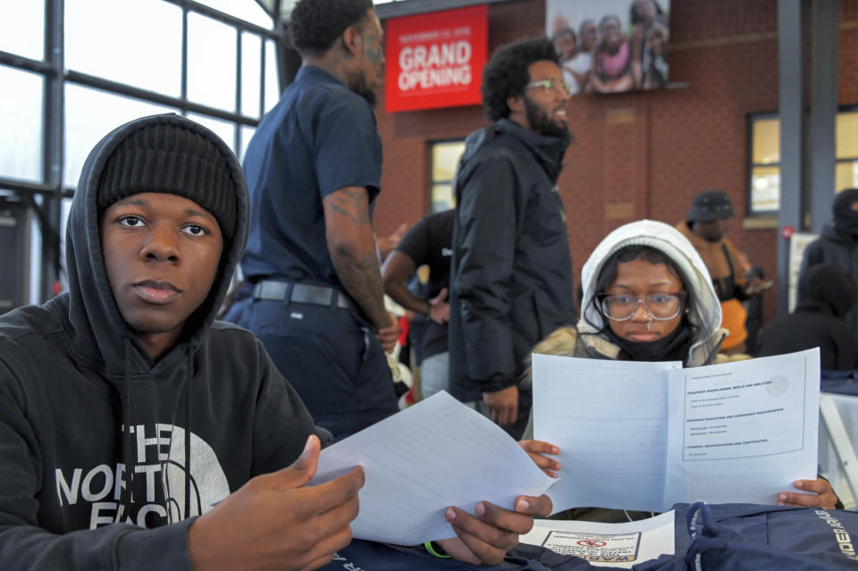 Schoolmates Kheyon Martin, 17 and Ayauhna Stewart, 15, right, look over documents before interacting with jobs recruiters at UA House/Living Classrooms as city leaders, representatives from the Mayor's Office of African American Male Engagement and Downtown Partnership of Baltimore, squeegee workers and community members, attends a resource and hiring event for squeegee workers prior to the enforcement of "disallowed zones" Friday, Jan. 6, 2023, in Baltimore. (Karl Merton Ferron/The Baltimore Sun via AP)