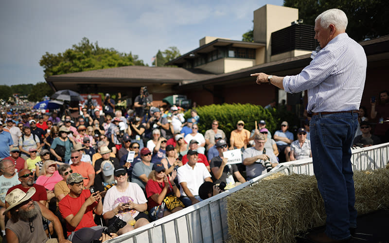 Mike Pence stands on hay bales as he speaks to a crowd of fairgoers