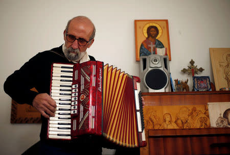 Christian artist and sculptor Naser Jeldha plays accordion in his studio in Gaza City December 4, 2016. REUTERS/Suhaib Salem