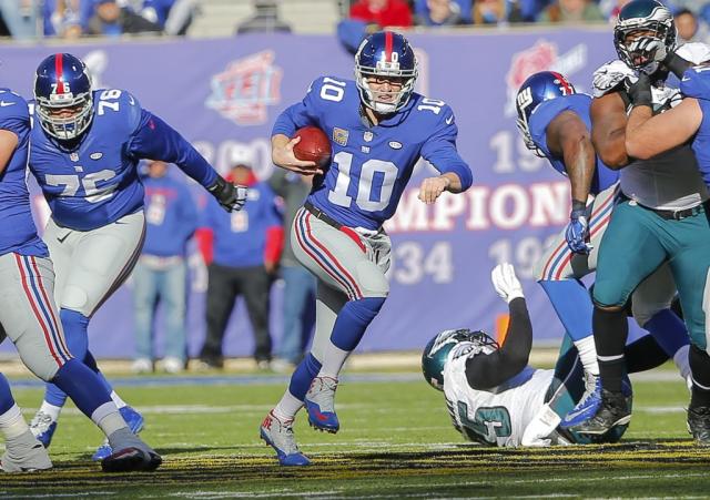 New York Giants runningback Tiki Barber takes a hand off from Eli Manning  in week 13 at Giants Stadium in East Rutherford, New Jersey on December 4,  2005. The New York Giants