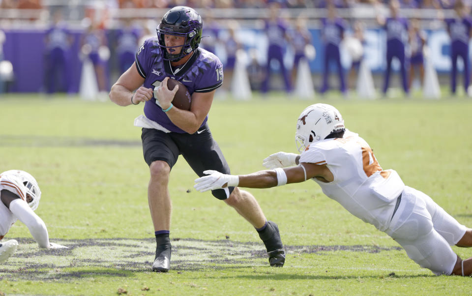 TCU quarterback Max Duggan (15) carries the ball for a first down as Texas defensive back Darion Dunn (4) attempts to make the tackle during the first half of an NCAA college football game Saturday, Oct. 2, 2021, in Fort Worth, Texas. (AP Photo/Ron Jenkins)