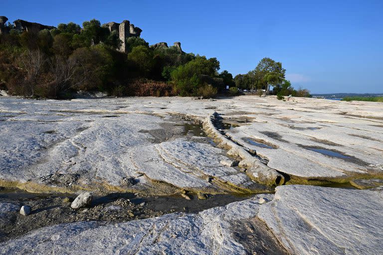 A picture taken on August 16, 2022 shows the rocks of the peninsula of Sirmione on Lake Garda, northern Italy, as the lake's waters recede due to severe drought. (Photo by MIGUEL MEDINA / AFP)