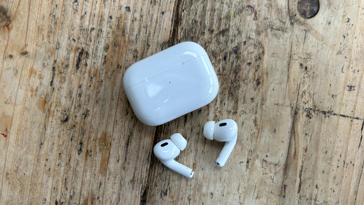  Apple AirPod 2 headphones next to case. 