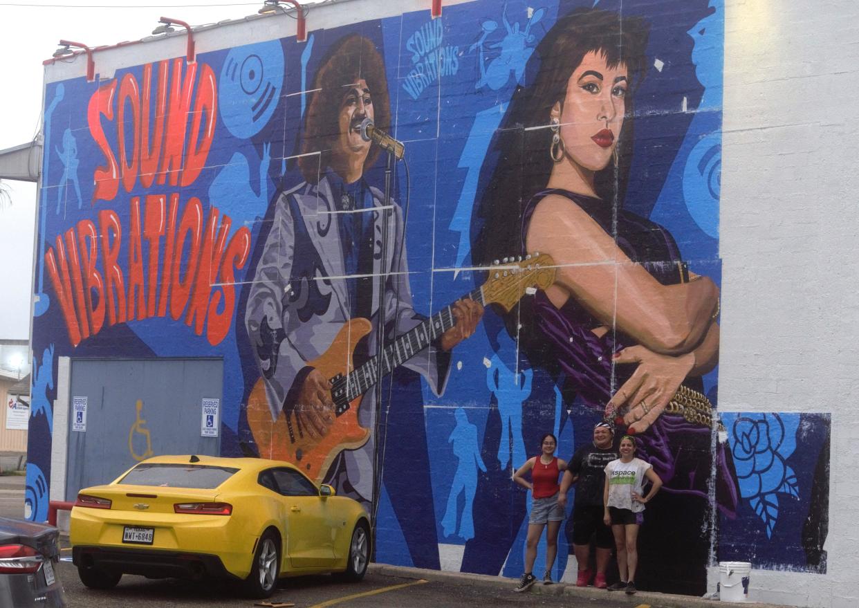 Pictured (from left) are assistant Emily Quintanilla and muralists Monica Marie Garcia and Mayra Zamora, who are working tirelessly to install the panels of their recently unveiled mural to be on display on the side of the Sound Vibrations music store in Six Points.