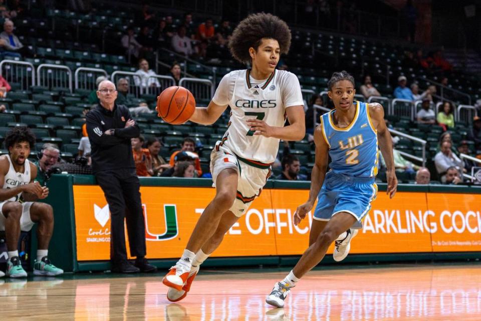 Miami Hurricanes guard Kyshawn George (7) dribbles past Long Island University guard Eric Acker (2) during the second half of an NCAA basketball game at the Watsco Center in Coral Gables, Florida, on Wednesday, December 6, 2023.