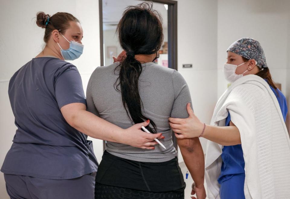 Surgical tech Carissa and recovery room staff member Elise walk a Texan patient to the recovery room following her abortion at the Trust Women clinic in Oklahoma City (Reuters)