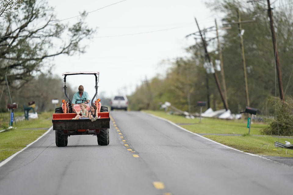 A farmer moves down a road on Friday, Aug. 28, 2020, in Homewood, La., in the aftermath of Hurricane Laura. (AP Photo/Gerald Herbert)