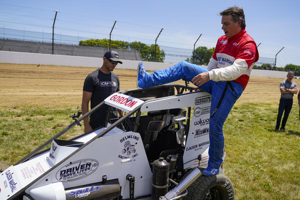 Jeff Gordon, a five-time winner of the Brickyard 400 and four-time NASCAR Cup Series champion, climbs into a USAC midget car before taking some exhibition laps on the dirt track in the infield at Indianapolis Motor Speedway in Indianapolis, Thursday, June 17, 2021. (AP Photo/Michael Conroy)