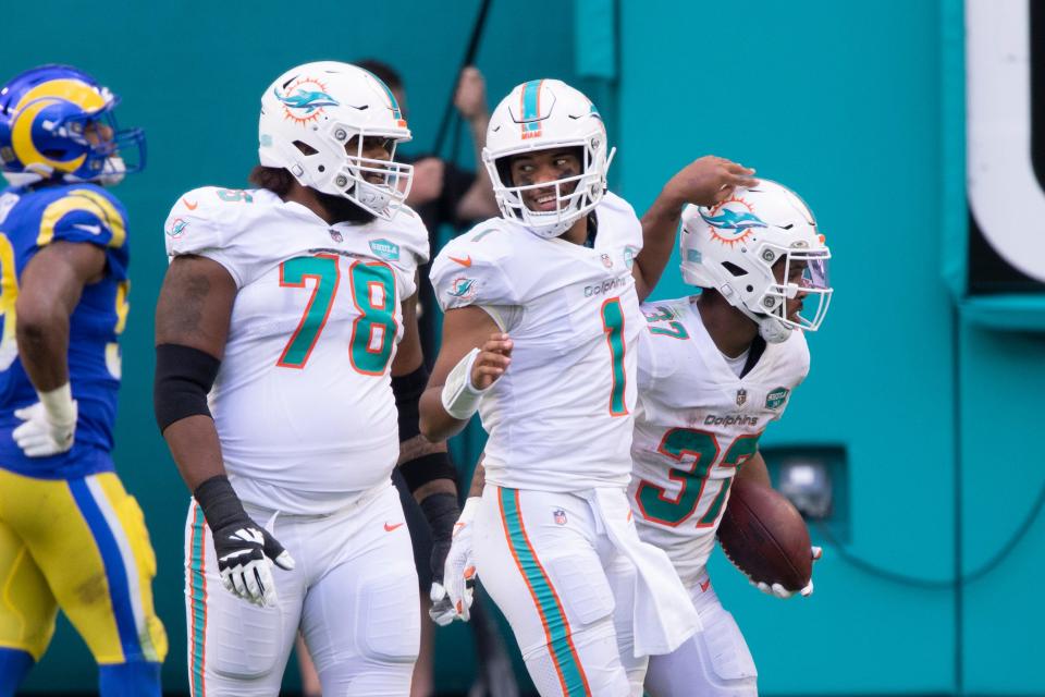 Miami Dolphins quarterback Tua Tagovailoa (1) smiles as he celebrates with Miami Dolphins tackle Adam Pankey (78) after Miami Dolphins running back Myles Gaskin (37) scoring a touchdown against the Los Angeles Rams during an NFL football game, Sunday, Nov. 1, 2020, in Miami Gardens, Fla. (AP Photo/Doug Murray)