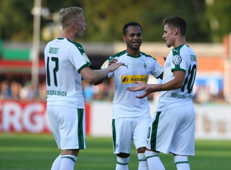 Borussia Moenchengladbach's Swedish defender Oscar Wendt celebrates a goal with Raffael and Thorgan Hazard