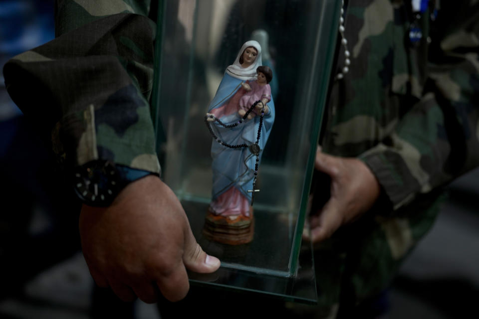 A veteran holds a statue of the Virgin Mary at a war memorial during a ceremony marking the 42nd anniversary of the conflict between Argentina and Great Britain over the Falkland Islands or Malvinas Islands in Buenos Aires, Argentina,Monday, April 1, 2024. (AP Photo/Natacha Pisarenko)