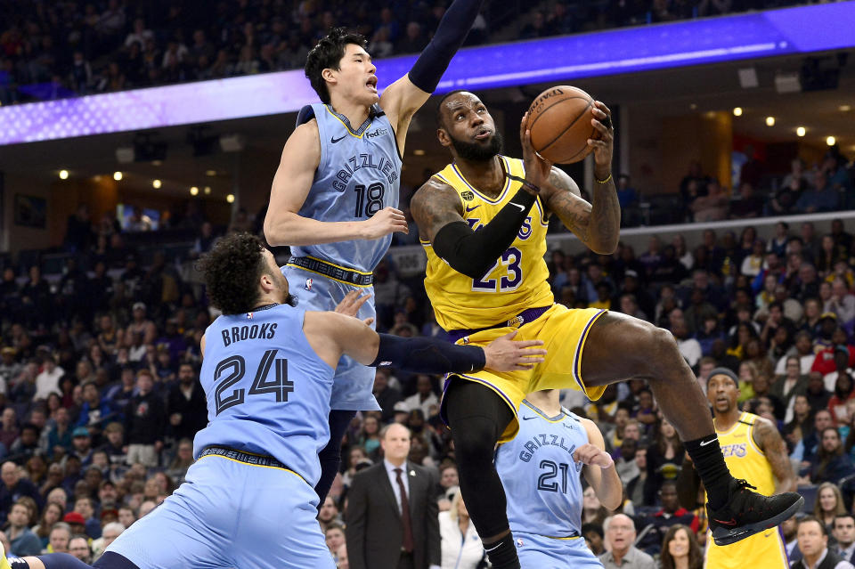 Los Angeles Lakers forward LeBron James (23) shoots ahead of Memphis Grizzlies guards Yuta Watanabe (18) and Dillon Brooks (24) in the second half of an NBA basketball game Saturday, Feb. 29, 2020, in Memphis, Tenn. (AP Photo/Brandon Dill)