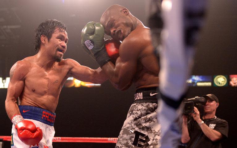 Timothy Bradley of US (R) covers up against Manny Pacquiao of Philippines (L) during their WBO World Welterweight Championship title match at the MGM Grand Arena in Las Vegas, Nevada on April 12, 2014