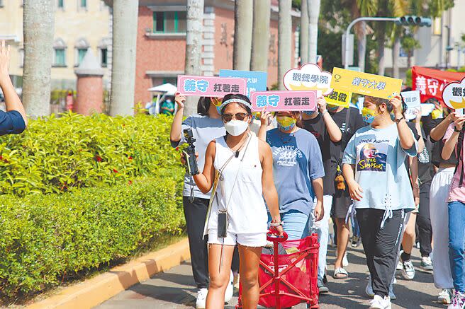 義守大學觀光餐旅學院休閒事業管理學系畢業香港學生梁凱熙，為了在返回香港前深刻體驗台灣，從6月30日起展開徒步環島，昨天完成100天的旅程，走回校園，師長、學弟妹與旅程結識的阿姨在校門口歡迎她。（林雅惠攝）