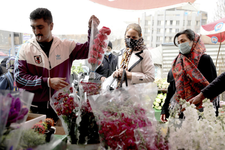 Customers buy flowers to celebrate the Persian New Year, or Nowruz, meaning "New Day." in northern Tajrish Square, Tehran, Iran, Wednesday, March 17, 2021. (AP Photo/Ebrahim Noroozi)